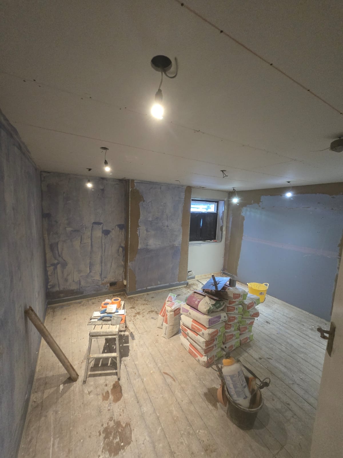 Large room being replastered with materials on site